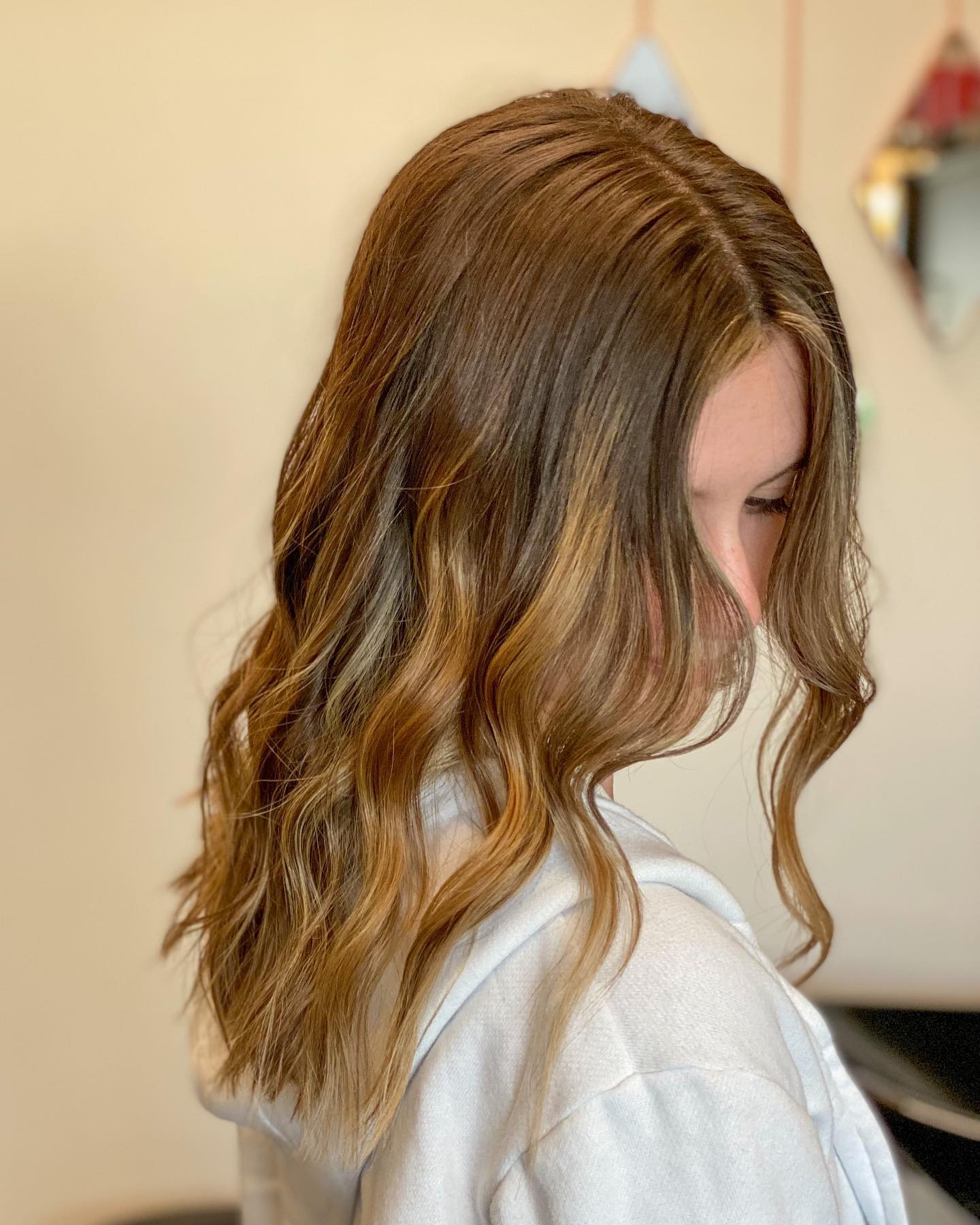 Brunette waves with warm caramel ribbons.