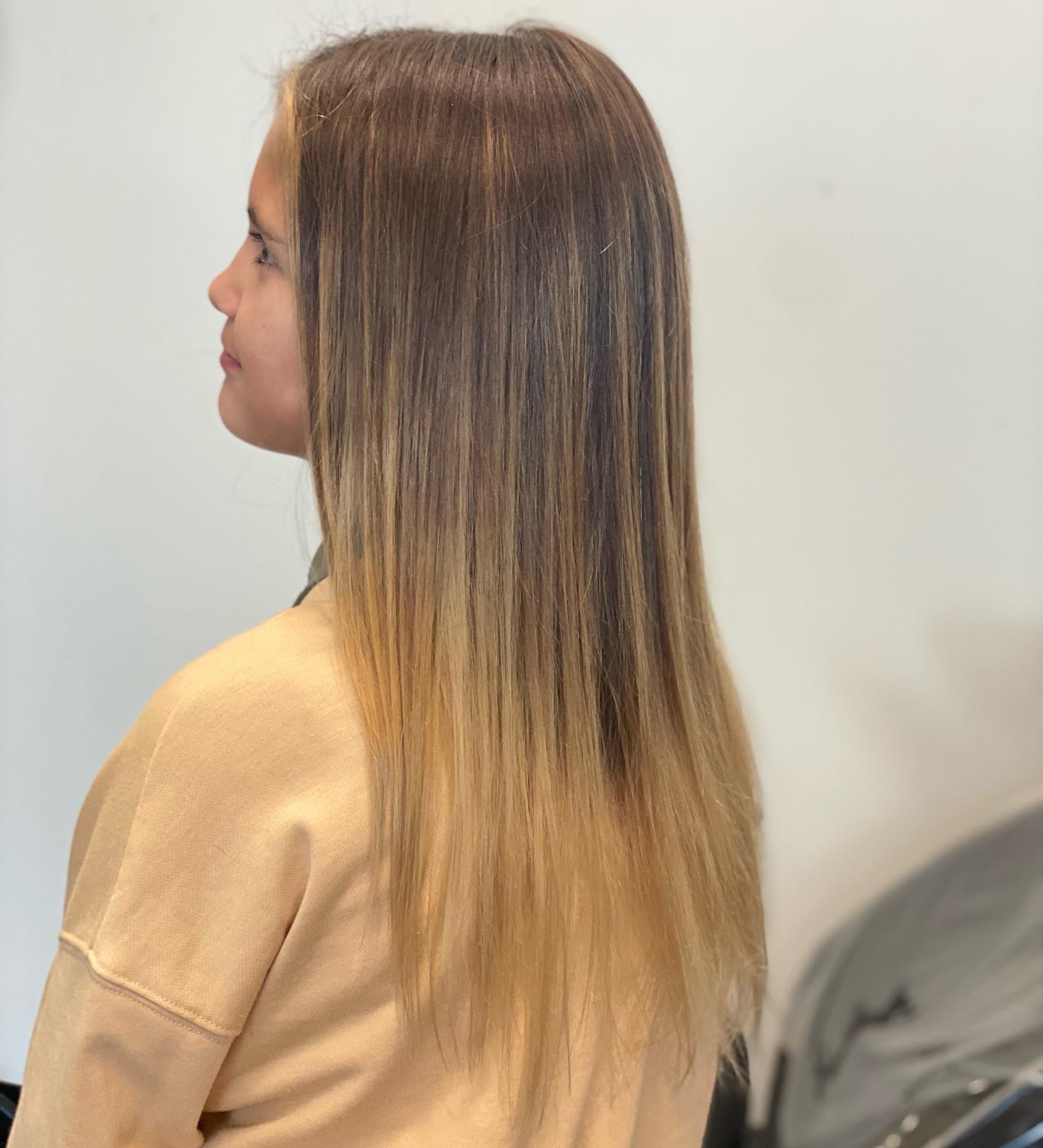 Long straight blonde hair with a soft shadowed root.