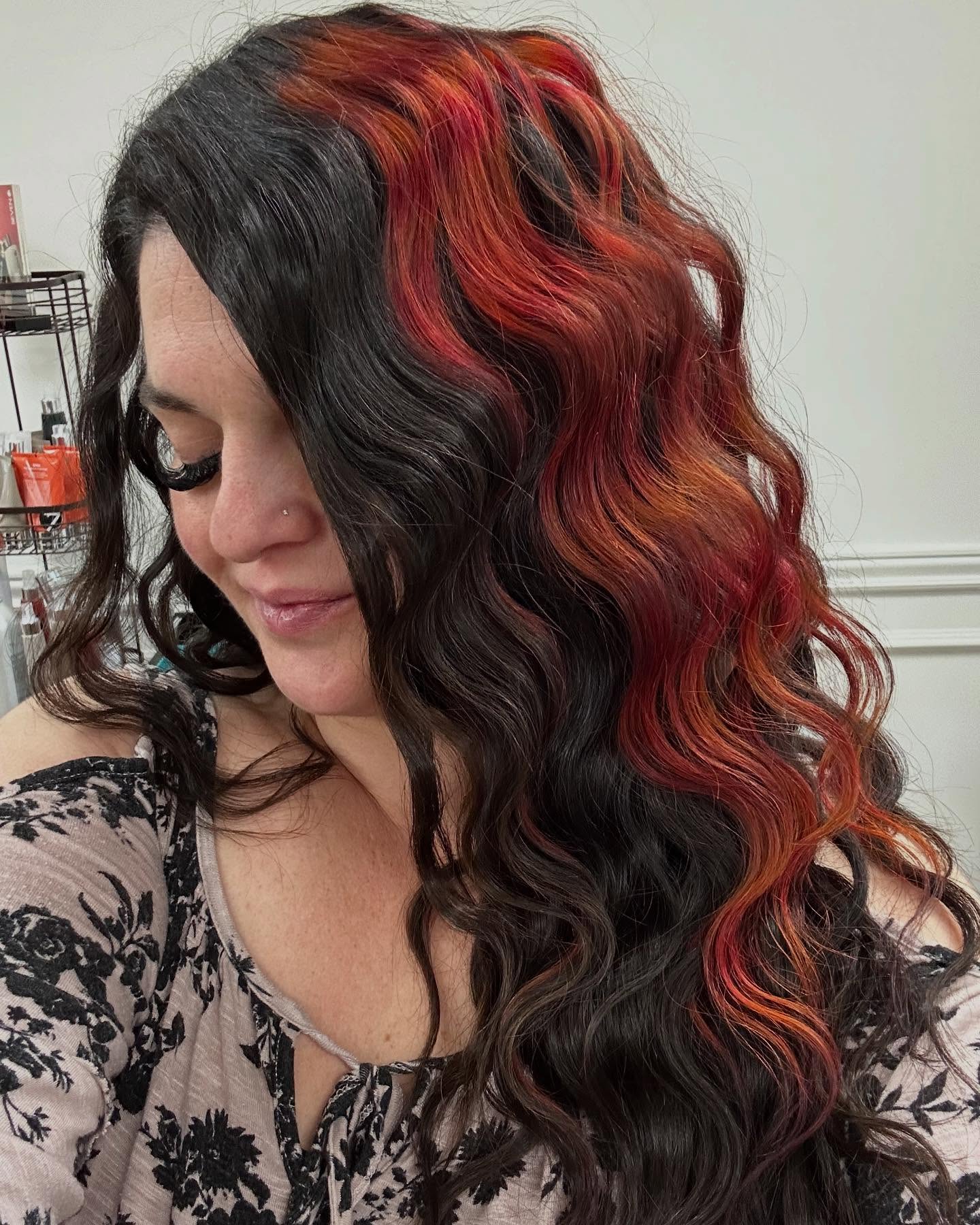 Long dark waves with vivid copper-red ribbons around the face.