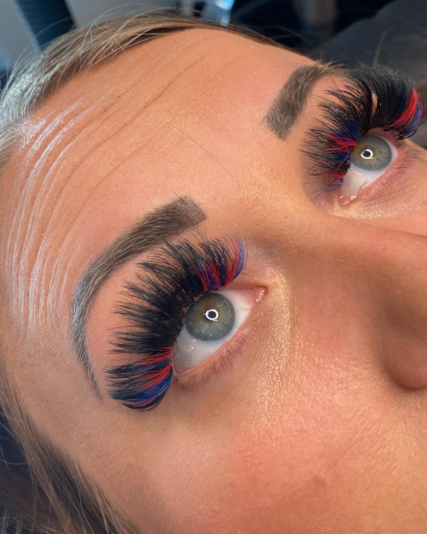 Full dark lashes accented with red and blue strands.