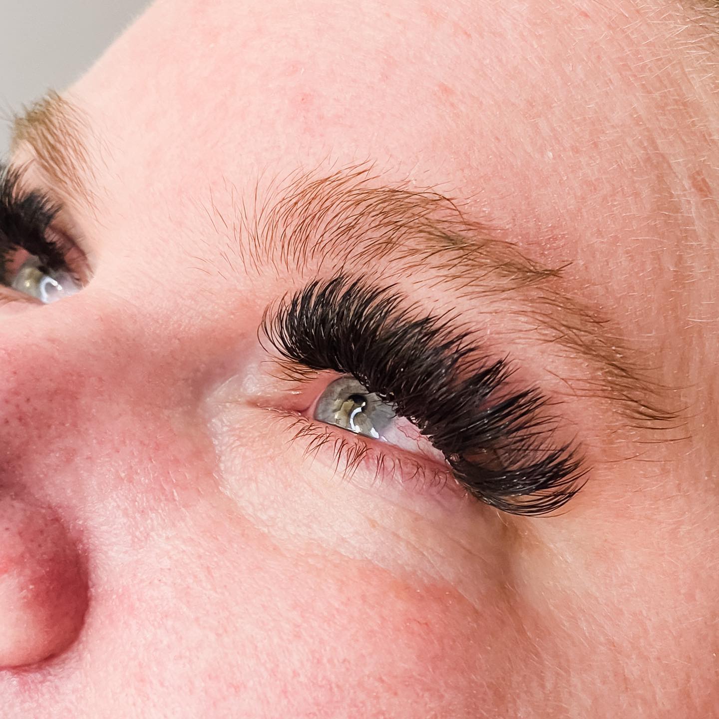 Close-up of full, softly fanned dark lashes.
